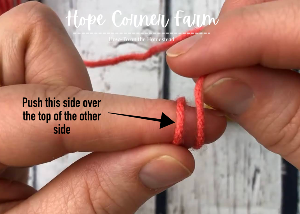 Push the yarn tail over the other piece of yarn