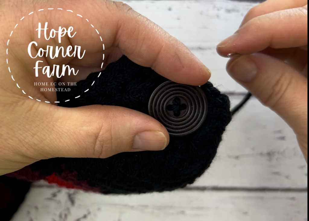 Sewing the button onto the crochet buffalo plaid flower headband