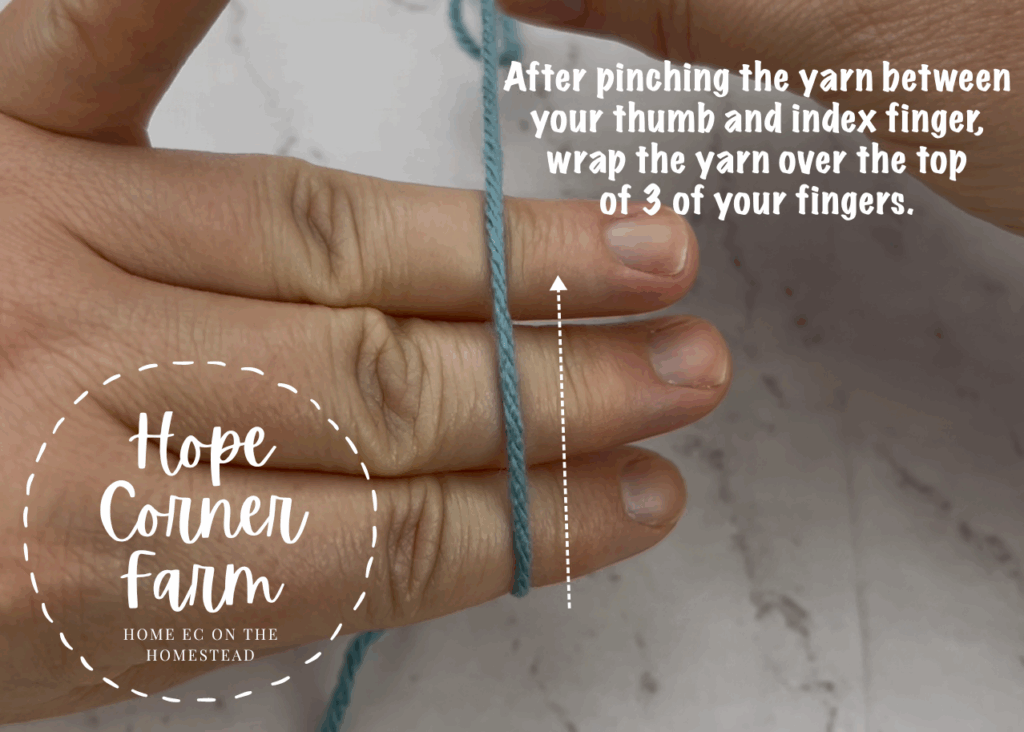 Wrap the yarn over the top of the 3 fingers