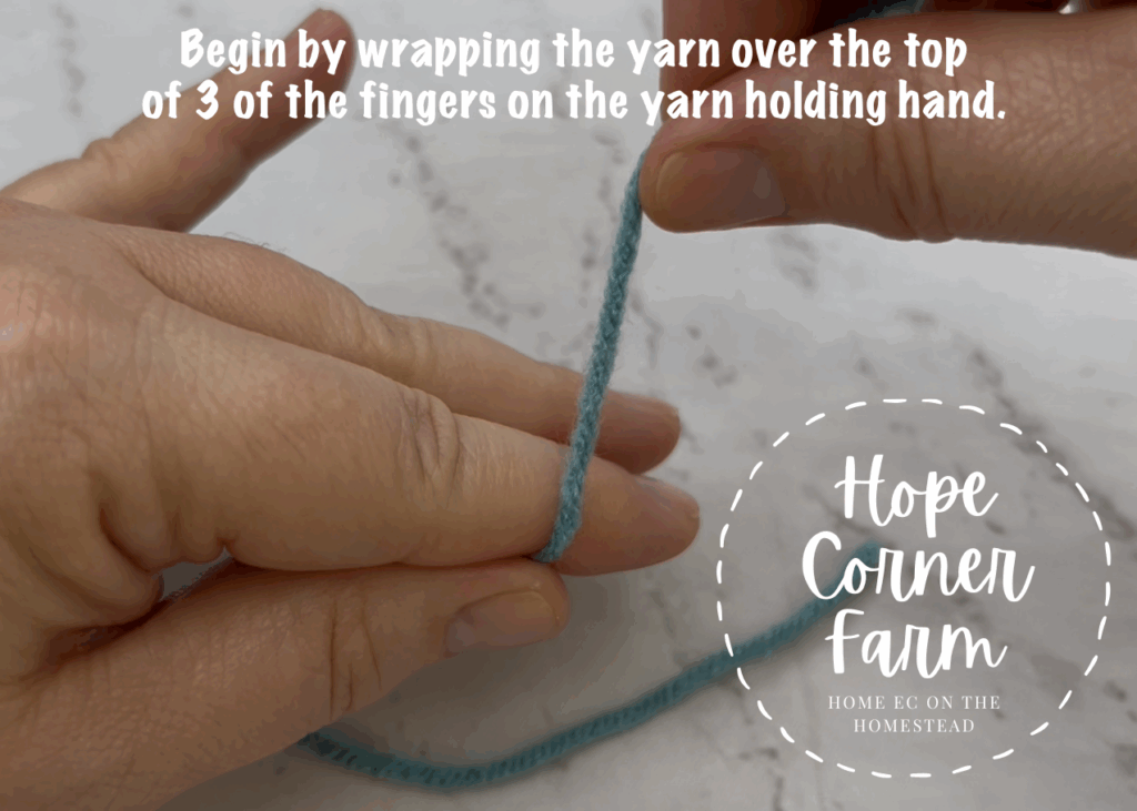 Begin by wrapping the yarn over the top of 3 of the fingers on the yarn holding hand