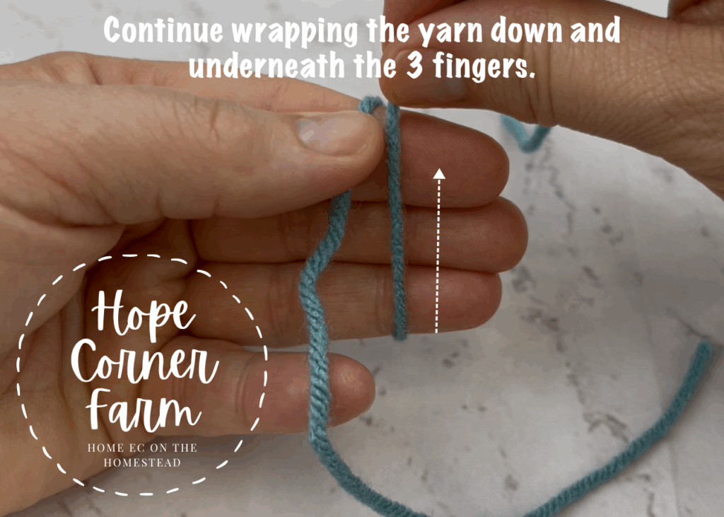 Continue wrapping the yarn down and underneath the 3 fingers